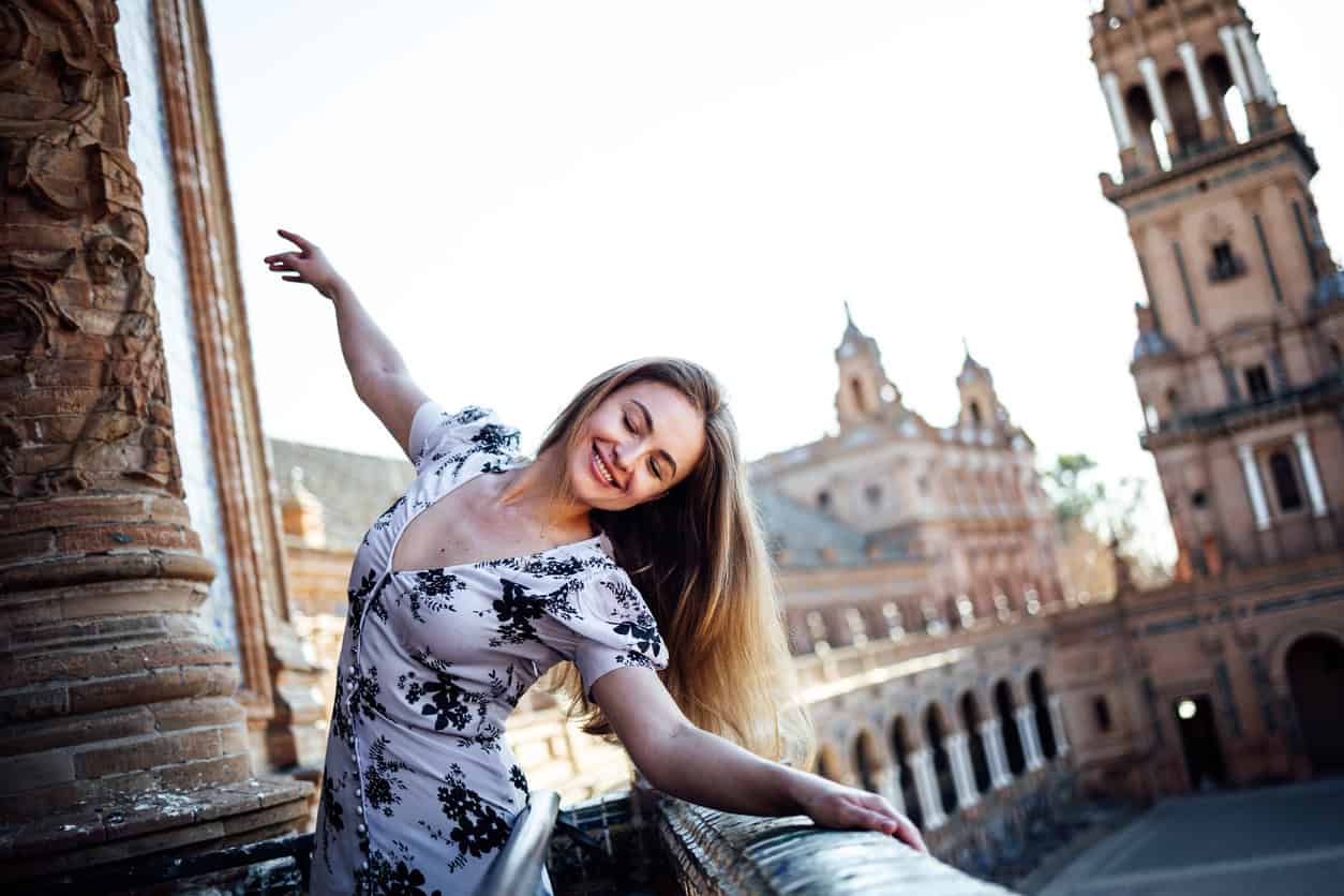 Young woman enjoying life dancing in summer dress visiting Spain - What to wear in Seville in July